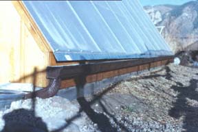 One long continuous gutter collects water off the glazing wall and delivers it to a 120 gallon stock tank
