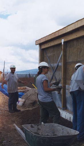 Local young adults are learning how to stucco as they put on the first coat of cement on the straw bale wall (inside and outside). They also put the first coat of wood sealer on the south glazing wall frame and the plywood on the east and west end walls